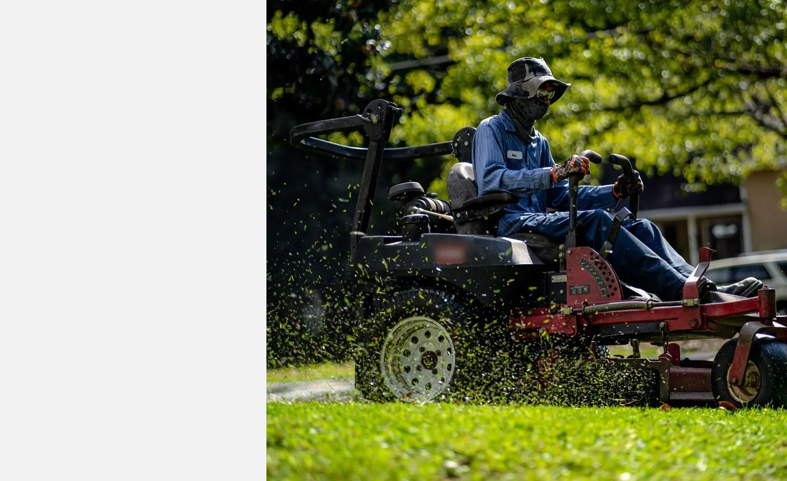 Lawn care technician mowing a lawn with a ride-on mower